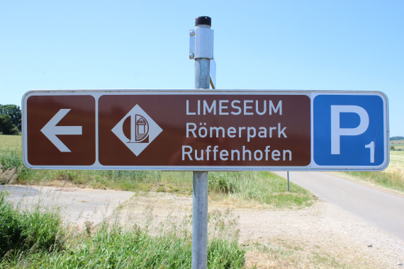 braunes Verkehrsschild imt Pfeil als Wegweiser zum LIMESEUM Römerpark Ruffenhofen und Hinweis zu Parkplatz 1